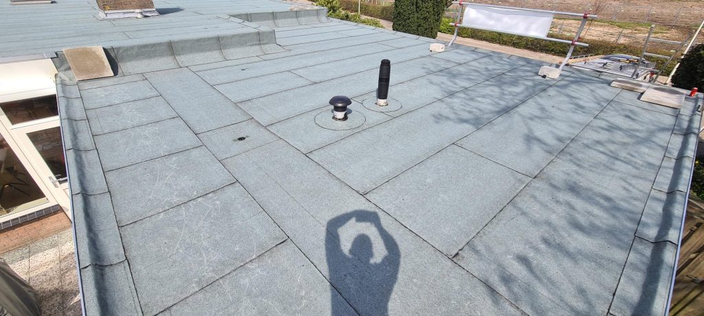 Plat dak van een woning in Goes na het overlagen met 1-laags bitumen dakbedekking met lichtgrijze leislag