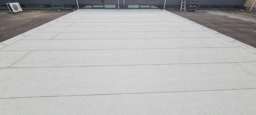 Plat dak van bedrijfspand in Goes met nieuwe witte bitumineuze dakbedekking en teruggeplaatste airco-units
